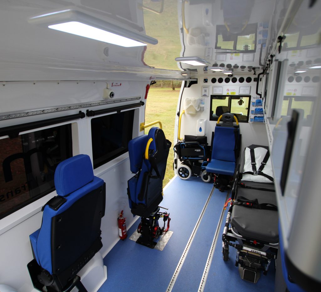 Inside of a EMA private ambulance showing a bariatric stretcher, wheelchair and accompanying seats